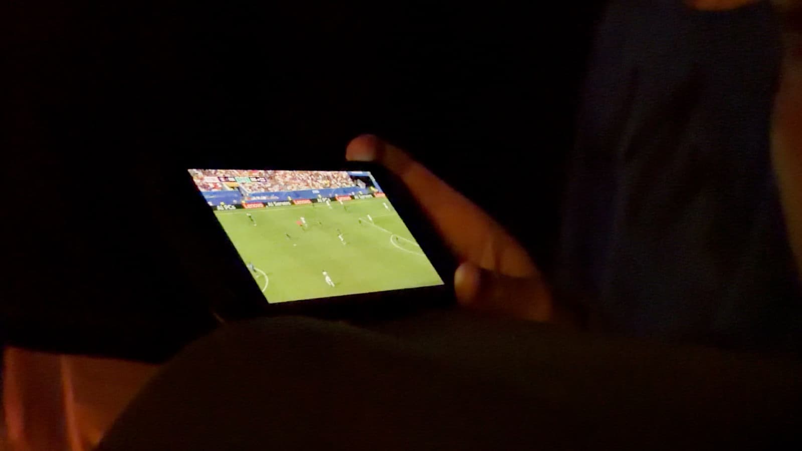 Een deelnemer kijkt in de tent naar een voetbalwedstrijd