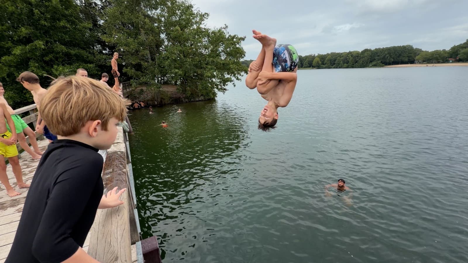 Een deelnemer maakt een backflip boven het water