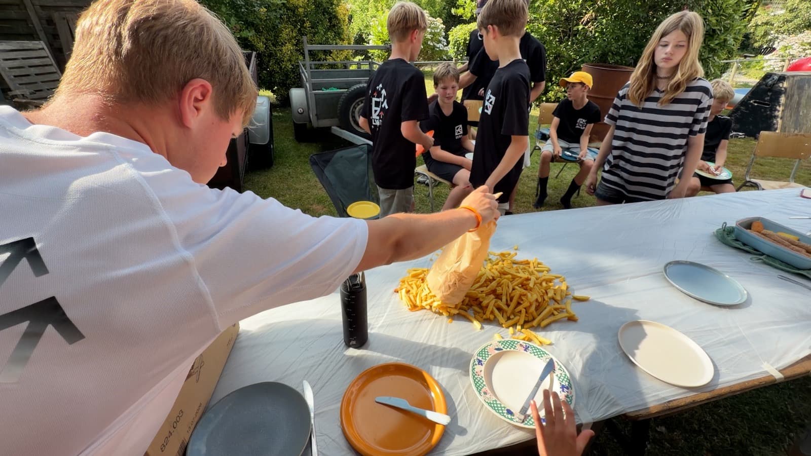 Deelnemers wachten samen op de friet