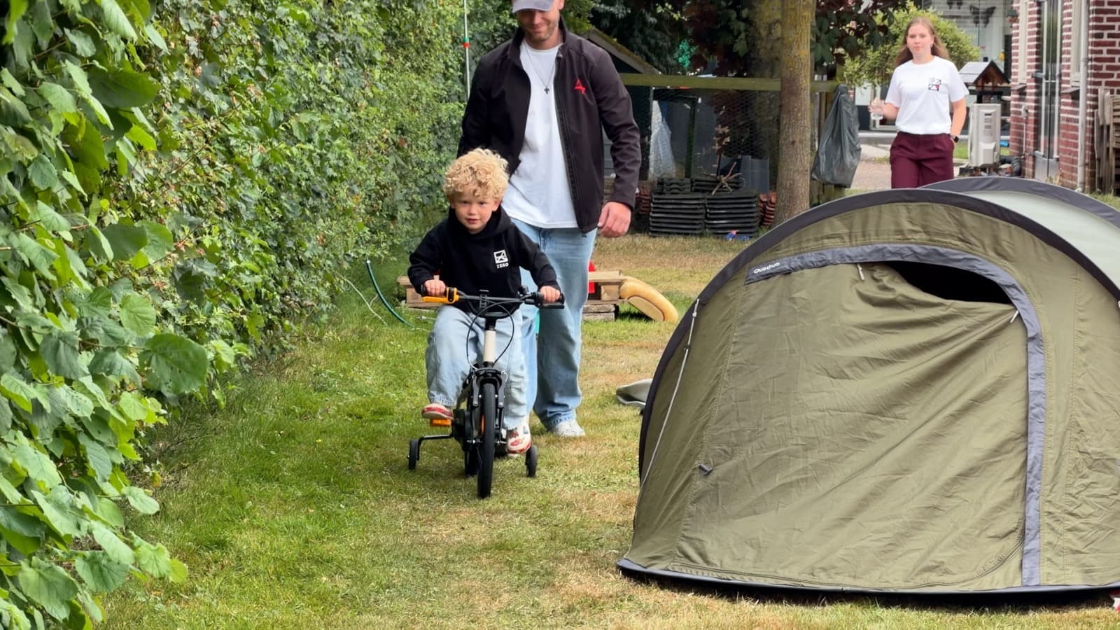 Een jonge bezoeker fietst tussen de tenten