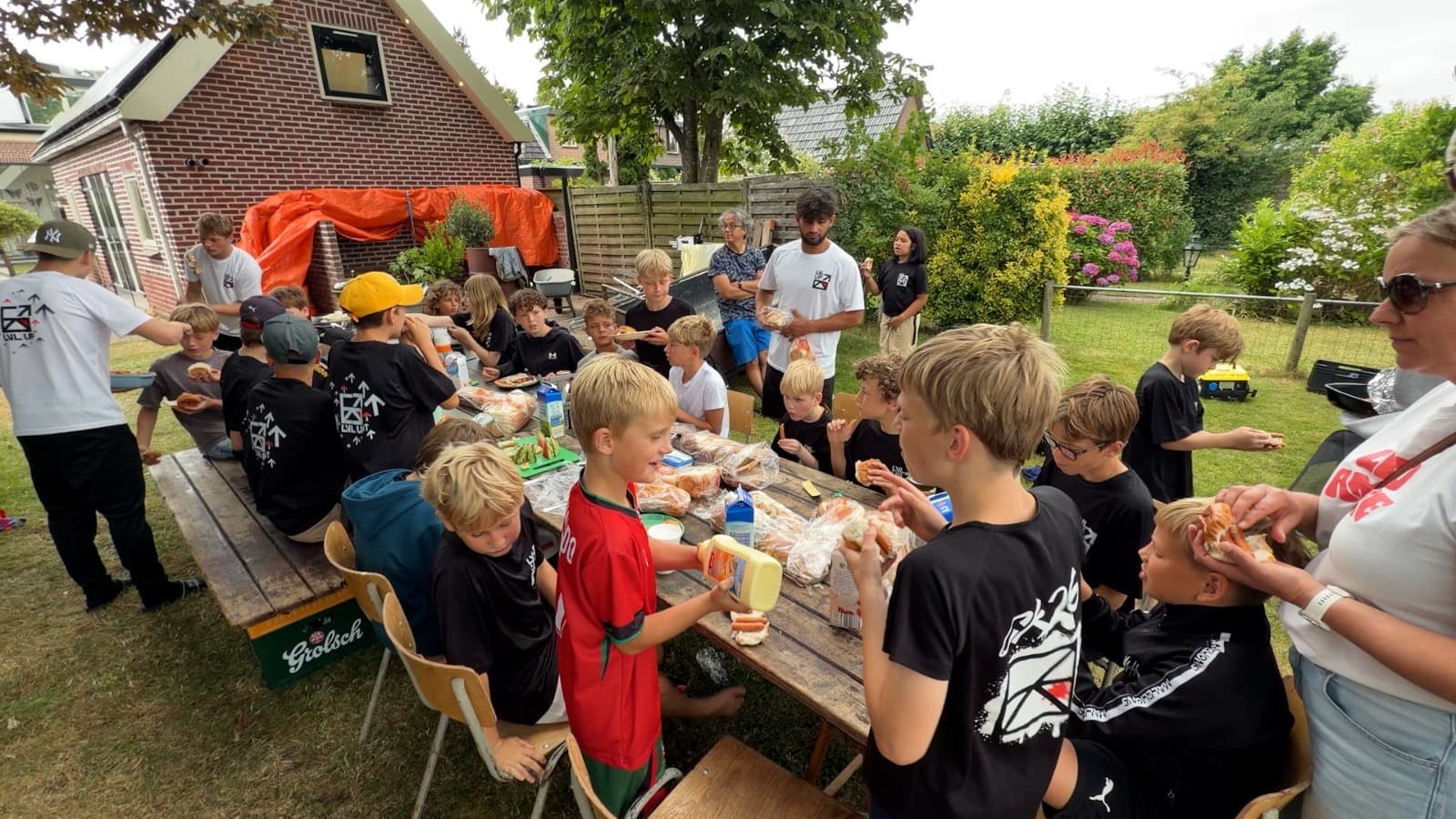 De hele kampgroep eet samen buiten aan lange tafels