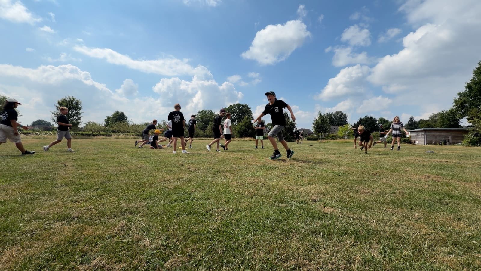 Deelnemers spelen samen een spel op een groot grasveld